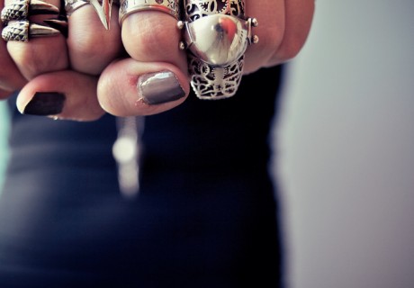 A lady holding out both clenched fists to show off her rings.